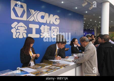 ------ Chinesische Mitarbeiter die Besucher am Stand von Xcmg während der 2012 Internationale Fachmesse für Baumaschinen, Baustoffmaschinen M Stockfoto