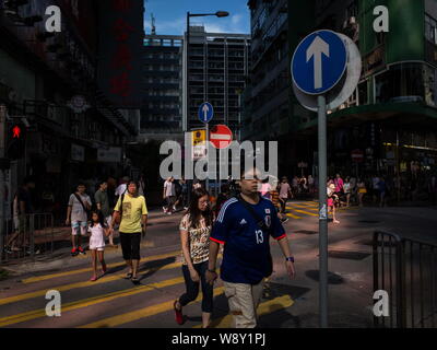 Fußgänger zu Fuß über eine sonnendurchflutete Straße in Prince Edward, Hongkong, China, 9. September 2014. Diese Fotos wurden von einem ausländischen Fotografen, der genommen Stockfoto