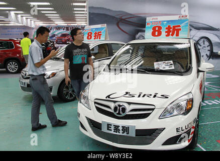 ---- Besucher an einem BAIC E-Serie Auto während eines Auto Show in Beijing City, South China Hainan Provinz, 28. Juni 2014. Chinese State-ba Stockfoto