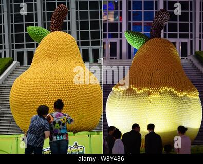 Das Bild zeigt die Leute an der riesigen Birne, verziert mit mehr als 15.000 Gummienten vor dem Grand Gateway Plaza in Shanghai, Stockfoto