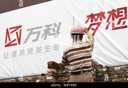 ---- Ein chinesischer Wanderarbeiter baut eine Mauer auf der Baustelle ein wohnprojekt von Vanke in Nantong City entwickelt, East China Stockfoto