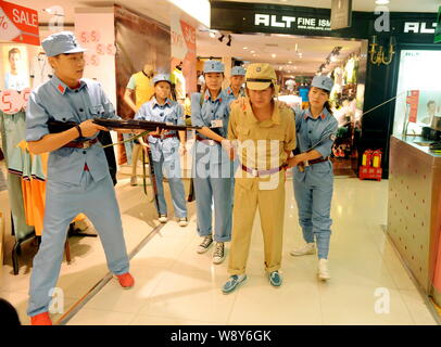 Chinesische Beamte in blauen Uniformen des 8. Route Armee escort ein Mitarbeiter in einer Uniform der japanischen Armee während des Zweiten Weltkriegs bekleidet gekleidet, Stockfoto