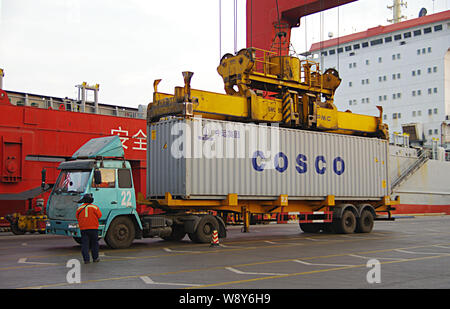 Ein Kran Fahrzeug entlädt einen Behälter mit Cosco im Ausland von einem Lkw am Hafen in Rizhao Rizhao Stadt versendet werden, East China Provinz Shandong, 29. Stockfoto