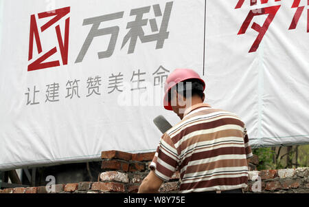 ---- Ein chinesischer Wanderarbeiter baut eine Mauer auf der Baustelle ein wohnprojekt von Vanke in Nantong City entwickelt, East China Stockfoto