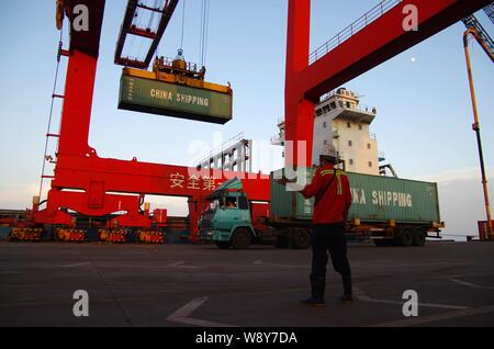 ------ Kran Fahrzeug entlädt einen Container von China Shipping aus einem Fahrzeug am Hafen in Rizhao Rizhao City, East China Provinz Shandong, 7 Augu Stockfoto