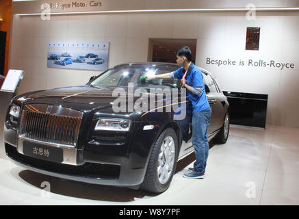 ---- Ein chinesischer Arbeiter Stäube aus einem Rolls-Royce Ghost Limousine auf der Auto Show in Beijing City, South China Hainan Provinz, 22. März 2014. Umsatz Stockfoto
