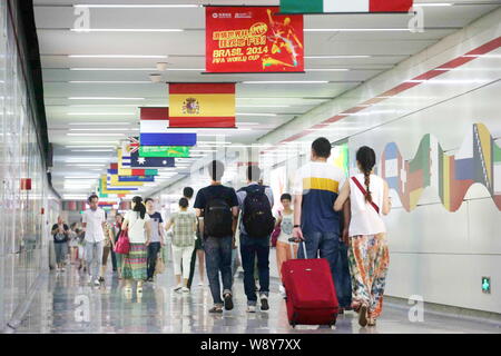 Passagiere unter nationalen Flaggen der Länder, die an der FIFA WM 2014 in einer U-Bahn-Station in Hangzhou City, East China Zhejian Stockfoto