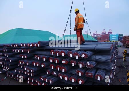 ---- Ein chinesischer Arbeiter leitet einen Kran zu Hoist Betonstahl bars In einem Stahlwerk in Rizhao City, East China Provinz Shandong, 18. Juli 2014. Stockfoto