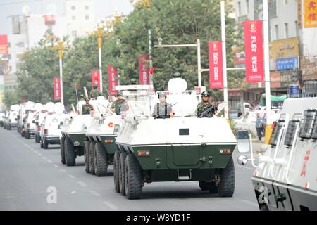 Bewaffnete Chinesischen paramilitärischen Polizisten stehen auf Patrouille Fahrzeuge während einer Patrouille in der Stadt Hotan, Northwest China Autonome Region Xinjiang Uygur, 6. Juni Stockfoto