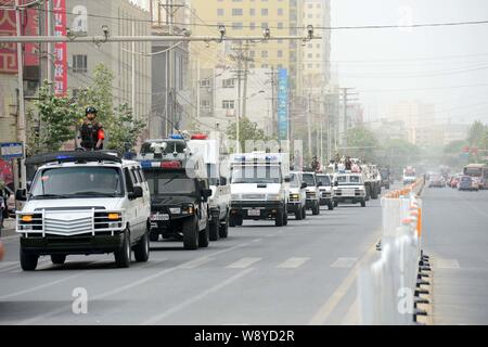 Bewaffnete Chinesischen paramilitärischen Polizisten stehen auf Patrouille Fahrzeuge während einer Patrouille in der Stadt Hotan, Northwest China Autonome Region Xinjiang Uygur, 6. Juni Stockfoto