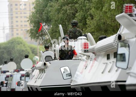 Bewaffnete Chinesischen paramilitärischen Polizisten stehen auf Patrouille Fahrzeuge während einer Patrouille in der Stadt Hotan, Northwest China Autonome Region Xinjiang Uygur, 6. Juni Stockfoto