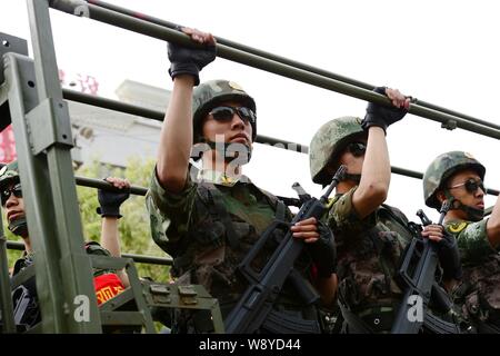 Bewaffnete Chinesischen paramilitärischen Polizisten stehen auf einer Patrouille Fahrzeug während einer Patrouille in der Stadt Hotan, Northwest China Autonome Region Xinjiang Uygur, 6 Jun Stockfoto