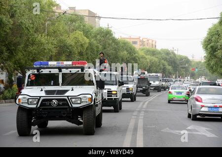 Bewaffnete Chinesischen paramilitärischen Polizisten stehen auf Patrouille Fahrzeuge während einer Patrouille in der Stadt Hotan, Northwest China Autonome Region Xinjiang Uygur, 6. Juni Stockfoto