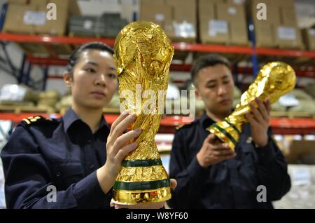 Die chinesischen Zollbeamten gefälschte Wm Trophäen, die Sie in einem Lager in Wuhan Stadt eingenommen prüfen, East China Zhejiang provinz, 16. April 2014. Mehr t Stockfoto