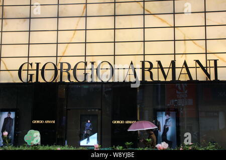 ---- Fußgänger vorbei ein Giorgio Armani store in Chongqing, China, 5. September 2013. Italienische Luxusartikel Marke Armani verkündete vor kurzem seine Stockfoto