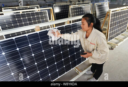 ---- Eine weibliche chinesischer Arbeiter Stäube aus Solarzellen im Werk von Shandong Hilight Solar Co., Ltd. in Zouping County, Binzhou City, East China S Stockfoto