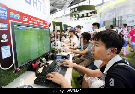 Besucher spielen elektronische Fußballspiele auf Desktop Computern während der 12. China Digital Entertainment Expo, auch als ChinaJoy 2014 bekannt, in Shangha Stockfoto