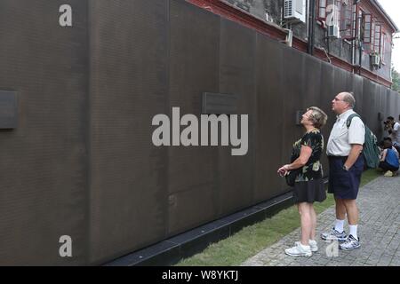 Ausländische Besucher Blick auf ein Kupfer Wand mit den Namen aller jüdischen Menschen Zuflucht in Shanghai Shanghai jüdische Flüchtlinge genommen zu haben Stockfoto