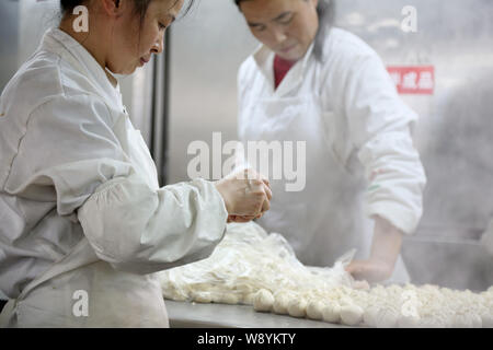 Chinesische Mitarbeiter machen sie Kleine gedämpfte Brötchen an einem Shanshan gedämpft Knödel Restaurant einer Kette in Shanghai, China, 19. März 2014. Stockfoto