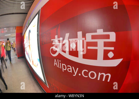 Passagiere vorbei an einer Werbung für Alipay mobile Payment Services von Alibaba Group in Shanghai, China, 8. Dezember 2014. Alipay, ein on-line-p Stockfoto