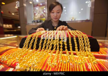 ---- Eine chinesische Angestellte zeigt Gold Halsketten an einem Juwelier in Lanzhou City, East China Jiangsu Provinz, 31. Oktober 2014. Kühlung der Chinesischen Stockfoto