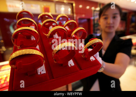 ---- Eine chinesische Angestellte zeigt goldene Armbänder zu einem Juwelier in Lanzhou City, East China Jiangsu Provinz, 3. September 2014. China wird geben Stockfoto