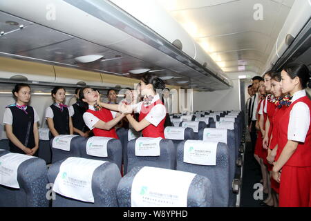 Junge chinesische Studenten Air Hostess Uniformen gekleidet lernen, Wing Chun, ein Konzept-basierte Chinesische Kampfkunst, an Bord ein mock Airbus A330 Kabine an Sichuan Stockfoto