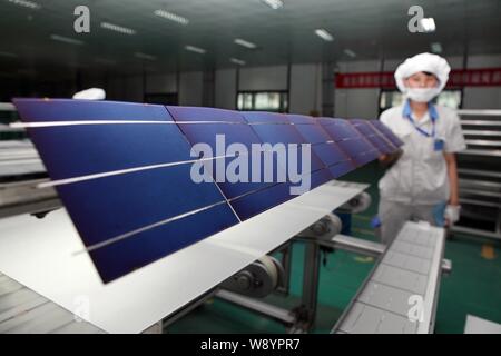 ---- Eine weibliche chinesischer Arbeiter überwacht die Produktion von Solarzellen für Solarmodule nach Europa und in die Vereinigten Staaten an der Anlage ausgeführt werden Stockfoto