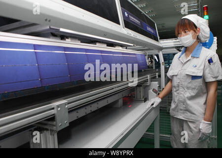 ---- Eine weibliche chinesischer Arbeiter überwacht die Produktion von Solarzellen für Solarmodule nach Europa und in die Vereinigten Staaten an der Anlage ausgeführt werden Stockfoto