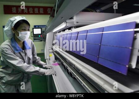 ---- Eine weibliche chinesischer Arbeiter überwacht die Produktion von Solarzellen für Solarmodule nach Europa und in die Vereinigten Staaten an der Anlage ausgeführt werden Stockfoto