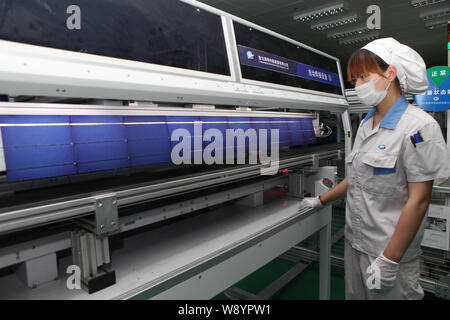 ---- Eine weibliche chinesischer Arbeiter überwacht die Produktion von Solarzellen für Solarmodule nach Europa und in die Vereinigten Staaten an der Anlage ausgeführt werden Stockfoto