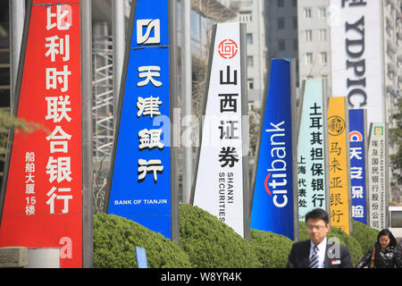 ---- Fußgänger vorbei an Schildern von chinesischen und ausländischen Banken und anderen Finanzinstituten in der Lujiazui Finanzviertel in Pudong, S Stockfoto