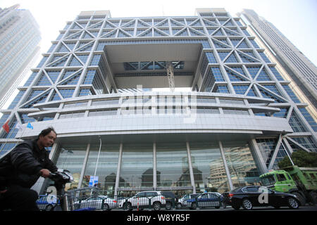 ---- Ein Mann fährt mit dem Elektrofahrrad Vergangenheit die Shanghai Stock Exchange Gebäude im Finanzviertel Lujiazui in Pudong, Shanghai, China, 11 Marc Stockfoto