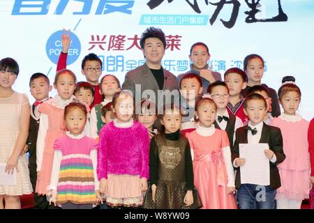 Chinesische Pianist Lang Lang, zurück, wirft mit kleinen Kindern während einer Pressekonferenz für die Shenyang Konzert seines China Tour in Shenyang City, n Stockfoto