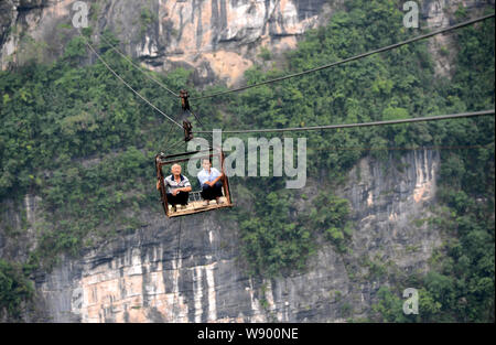 Lokale chinesische Dorfbewohner eiserner Käfig auf einem Satz von Leitungen ein Tal in Fuzhou Dorf zu kreuzen, Hefeng Stadt, Enshi Tujia, Miao Autonomo Stockfoto