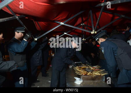 ------ Chinesische Offiziere von der Beijing Municipal Bureau von Stadtverwaltung und Polizei beschlagnahmt ein Grill und Nahrung an einem strassenrand barbec Stockfoto