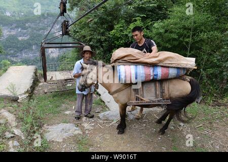 Lokale chinesische Dorfbewohner ein Esel eiserner Käfig auf einem Satz von Leitungen ein Tal in Fuzhou Dorf Kreuz installiert Fahrt vor, Hefeng Stadt, Enshi Tuj Stockfoto