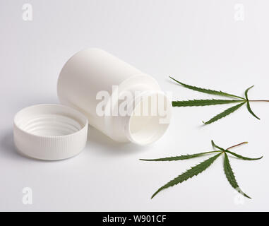 Öffnen leer aus weißem Kunststoff medizinische Jar für Pillen und grün Hanf Blatt auf einem weißen Hintergrund, alternative Medizin Konzept Stockfoto
