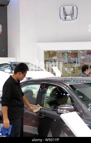 ---- Ein chinesischer Arbeiter Stäube aus ein Auto am Stand von guangqi Honda, ein Joint Venture zwischen GAIC und Honda, während ein Auto Show in Shanghai, China Stockfoto