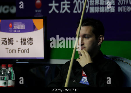 Tom Ford von England reagiert, als er beobachtet, Judd Trump von England spielen einen Schuß in ihren Viertelfinalegleichen während der 2019 World Snooker internationale Meisterschaft in Daqing Stadt, im Nordosten der chinesischen Provinz Heilongjiang, den 8. August 2019. Stockfoto