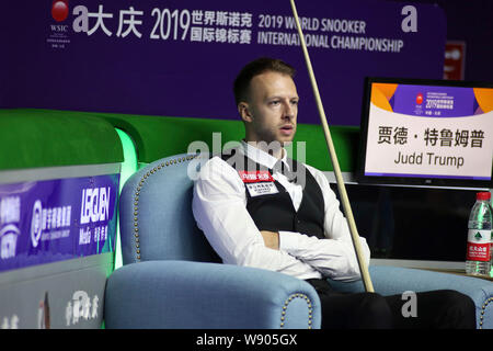 Judd Trump von England reagiert, wie er beobachtet Mark Selby von England spielen einen Schuß in ihrem Halbfinale während der 2019 World Snooker internationale Meisterschaft in Daqing Stadt, im Nordosten der chinesischen Provinz Heilongjiang, den 9. August 2019. Stockfoto