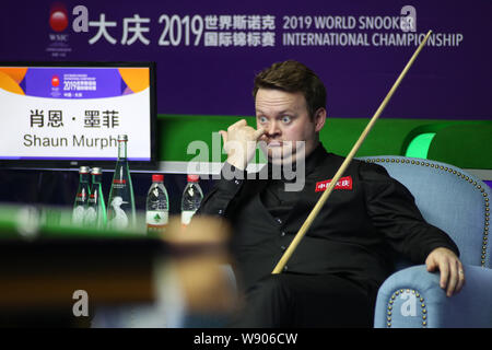 Shaun Murphy von England reagiert, als er beobachtet, Judd Trump von England spielen einen Schuß in ihrem letzten Spiel während der 2019 World Snooker internationale Meisterschaft in Daqing Stadt, im Nordosten der chinesischen Provinz Heilongjiang, 11. August 2019. Stockfoto