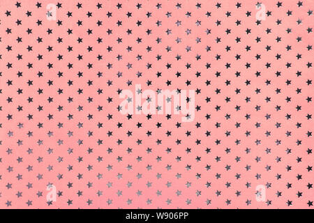 Rosa Hintergrund aus Metallfolie Papier mit einem Muster von funkelnden silbernen Sterne, Nahaufnahme. Textur von Rose metallisierte Verpackung urlaub Papier Oberfläche. Stockfoto