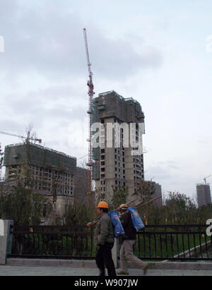 Chinesische Wanderarbeiter vorbei an hohen residential Apartment Gebäude im Bau in Hangzhou City, East China Jiangsu Provinz, 2 Janu Stockfoto