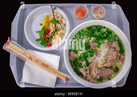 18-05-2019, Moskau, Russland. Vietnamesische Street Food, pho bo Suppe mit grünen und Reis, Mehl, Nudeln, Kunststoff Fach mit einer großen Schüssel Suppe serviert. Han Stockfoto
