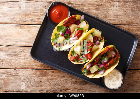 Mexikanische Tacos al Pastor, serviert mit Sauce closeup auf einem Teller auf den Tisch. horizontal oben Ansicht von oben Stockfoto