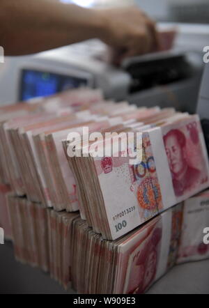 ---- Eine chinesische Angestellte verwendet eine Cash - Zählmaschine RMB (Renminbi) Yuan Banknoten bei einer Filiale der Landwirtschaftlichen Bank von China in Stadt Qionghai zu zählen Stockfoto