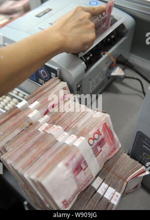 ---- Eine chinesische Angestellte verwendet eine Cash - Zählmaschine RMB (Renminbi) Yuan Banknoten bei einer Filiale der Landwirtschaftlichen Bank von China in Stadt Qionghai zu zählen Stockfoto