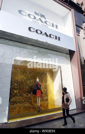 --FILE - eine moderne, junge Frau geht vorbei an der Fashion Boutique von At Westgate Mall in Shanghai, China, 10. Januar 2014 Trainer. Corina Su strebt nach Som Stockfoto