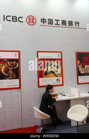 ---- Ein chinesischer Mitarbeiter ist auf dem Stand der ICBC (Industrielle und kommerzielle Bank von China) während einer Ausstellung in Shanghai, China, 23. November gesehen Stockfoto